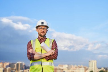 Şehir merkezinde miğfer ve güvenlik yeleği sahibi ya da mühendisi