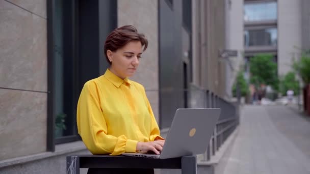 Exitosa mujer de negocios calificada con portátil en el centro de la ciudad — Vídeos de Stock