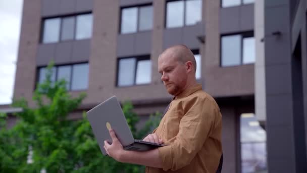 Homem de negócios com laptop trabalhando no centro urbano — Vídeo de Stock