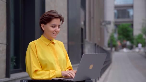 Retrato de la joven mujer de negocios alegre que trabaja en el ordenador portátil — Vídeo de stock