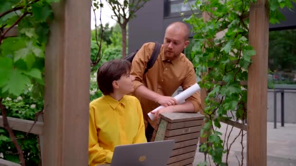 Business team bespreekt project outdoor op park met laptop — Stockvideo