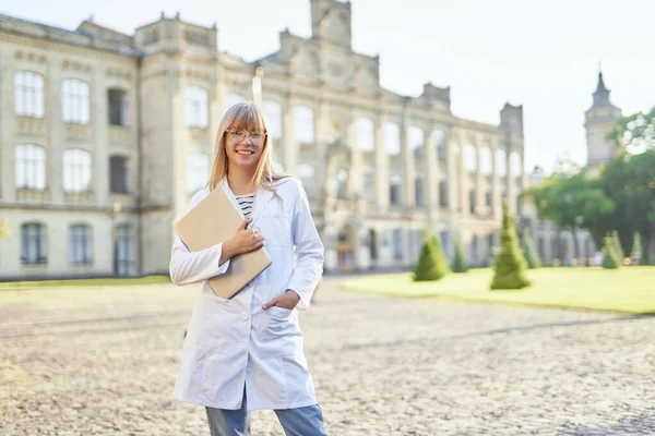 Cheerful student at medical university campus with laptop