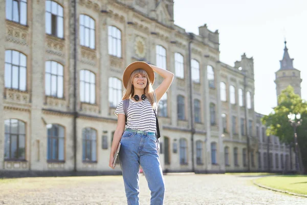 Studying abroad concept. University student girl in hat