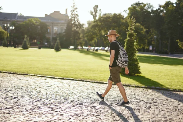 Traveller wearing hat and backpack going in European old city — Stock Photo, Image