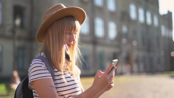 Turista feminino positivo em chapéu de palha usando telefone celular — Vídeo de Stock