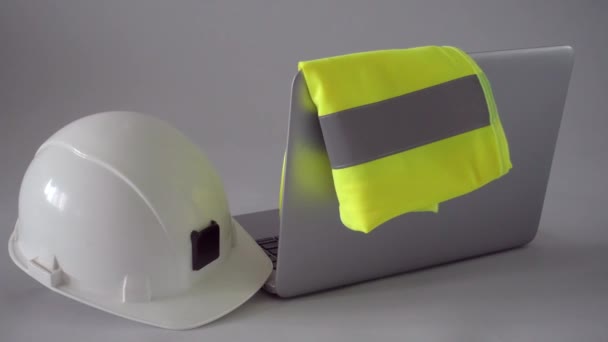 Construction: safety helmet and vest, laptop computer — Stock Video