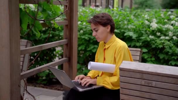 Linda mujer de negocios en blusa amarilla con portátil al aire libre — Vídeo de stock