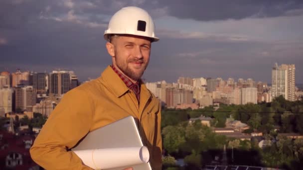 Foreman, supervisor portrait in helmet and laptop, city view — Stock Video