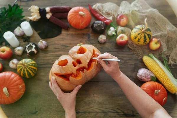 Rzeźbienie dyni na Halloween. Widok z góry dłoni z nożem — Zdjęcie stockowe