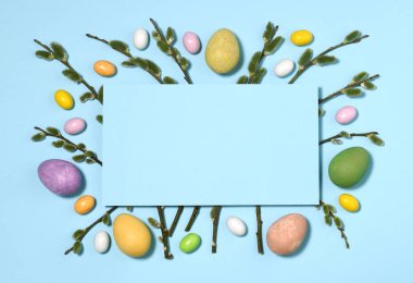 Mavi arka planda Paskalya yumurtaları ve söğüt dallarının düzenlenmesi