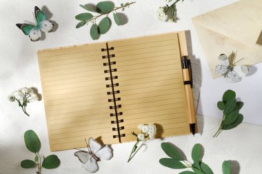 Boş defter. Kelebekler, çiçekler ve okaliptüs yaprakları.