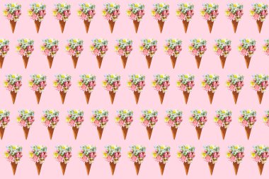 Çiçekli dondurma külahları pembe arka planda.