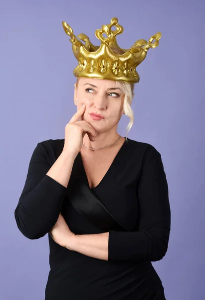紫色の背景に金色の冠を持つ陽気な女性の肖像画 — ストック写真