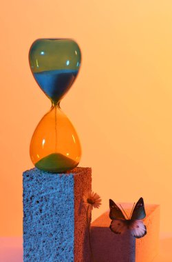 Kum saati, kelebek ve papatya mavi ve turuncu renklerde.