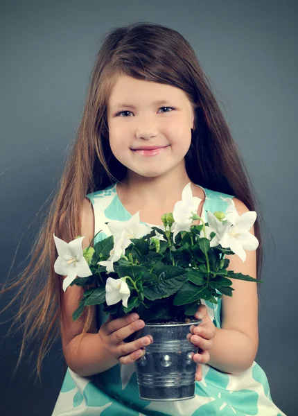 Liten flicka med blommor — Stockfoto