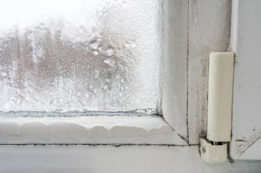 Hasarlı plastik bir pencereyi kapatın, içinde buğulanma ve donma var. Kötü havalandırma, yüksek nem ve sıcaklık farkları.