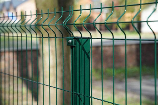 Steel grating fence made with wire on garden background. Sectional fencing installation                               