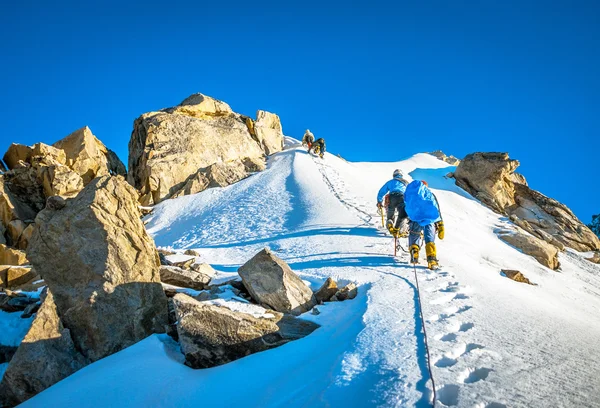 Gruppe von Bergsteigern erreicht den Gipfel des Berges. Klettern und Bergsteigen. Nepalgebirge. — Stockfoto