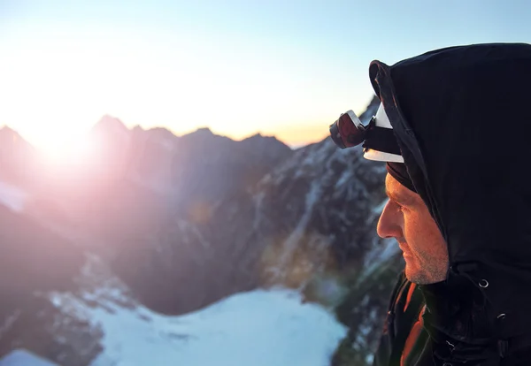 Bergbeklimmer bereikt de top van een besneeuwde berg — Stockfoto