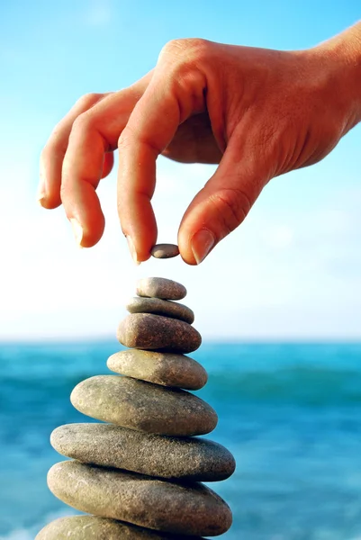 Abstrakter Hintergrund. Steinturm auf einem Kiesstrand — Stockfoto