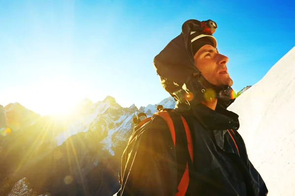 Mountaineer reaches the top of a snowy mountain — Stock Photo, Image