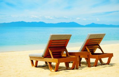 Chairs on the beautiful sandy beach near sea clipart