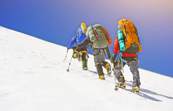 O alpinista atinge o topo do pico da montanha. Escalada e esporte de alpinismo. Montanhas . — Fotografia de Stock