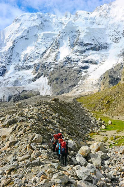 Dağcı bir karlı dağın tepesine ulaşır — Stok fotoğraf