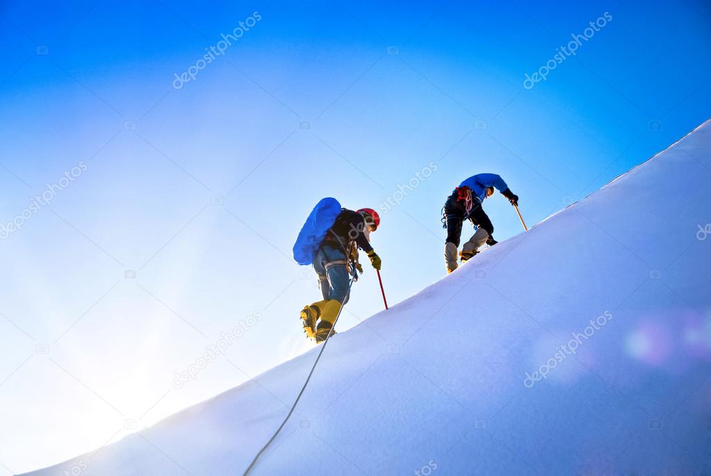 Group of climbers reaching the summit. 