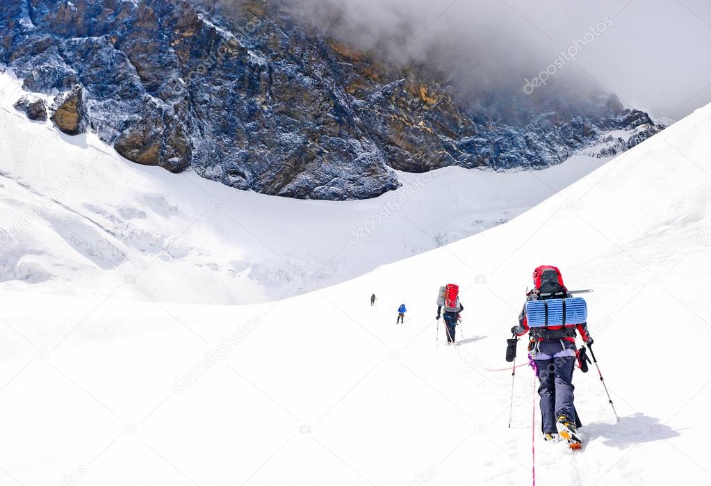 Group of climbers reaching the summit. 