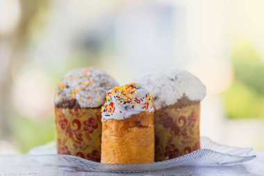 Doğada üç paskalya pastası yeşil bir bahar otunun arka planına karşı.