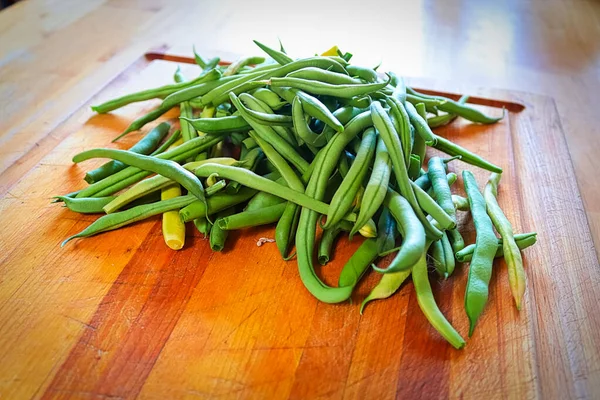 Frijoles verdes frescos en medio de una tabla de cortar —  Fotos de Stock