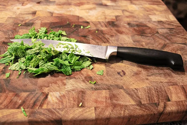 Primer plano de un cuchillo en una tabla de cortar con menta verde fresca — Foto de Stock