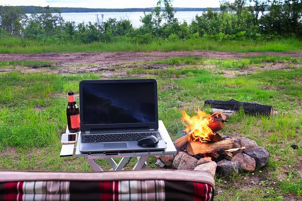Kempování s jezerem, laptopem, pivem a židlí na fotografii — Stock fotografie