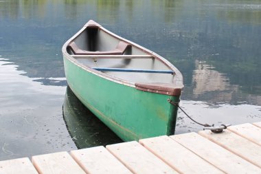 Tahta bir rıhtıma bağlanmış bir kano güvertesinin yakınına.