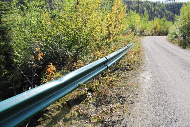 Çakıl yolunun kenarında bir koruma rayı.