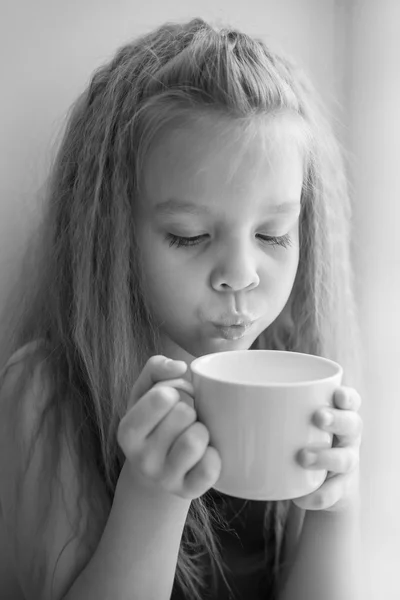 Retrato de uma menina com um copo de leite quente, foto em preto e branco — Fotografia de Stock