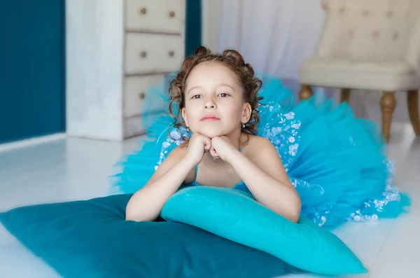 Menina em vestido azul deitado no chão — Fotografia de Stock