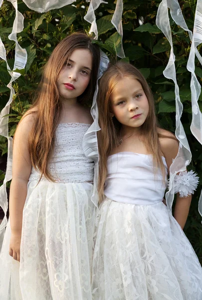 Retrato de duas meninas em vestidos brancos no jardim — Fotografia de Stock