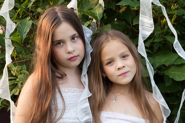 Retrato de duas meninas em vestidos brancos no jardim — Fotografia de Stock