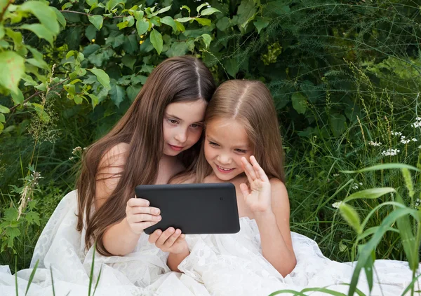 İki küçük kız bir bilgisayar başında konuşuyor — Stok fotoğraf