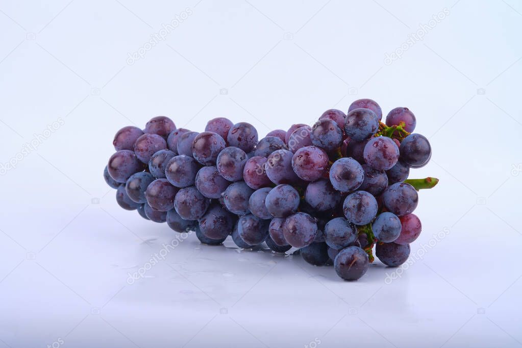 Kyoho grapes (giant mountain grapes) , with some grapes scattered out in front. Isolated on white.