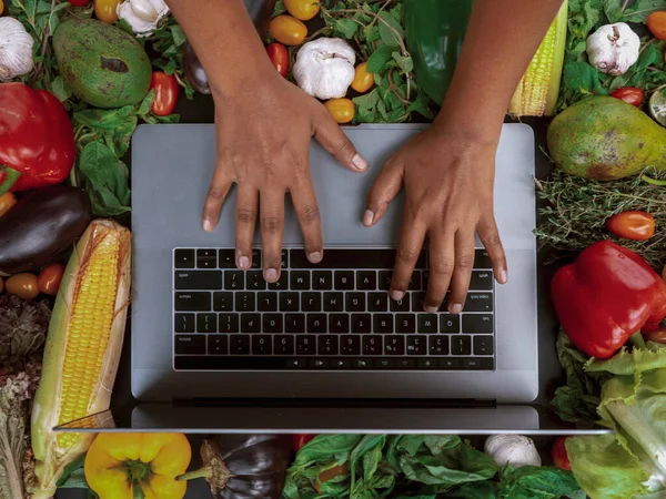 Online food ordering. Vegetables, laptop, hands.