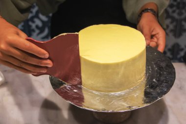 Şekerleme spatulası ile bisküvi pastası üzerine beyaz krema. Ev yapımı hamur işi, kek pişirme....