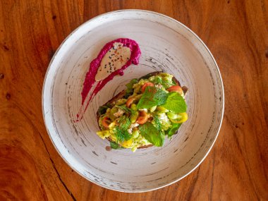 Yumuşak gevrek ekmeğin üzerinde avokado salatası.