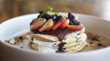 Böğürtlenli ve meyveli krepler beyaz tabakta