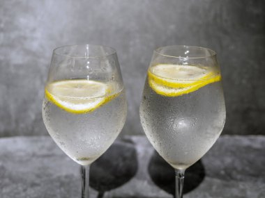 Gri beton arka planda limonlu bardaklar.