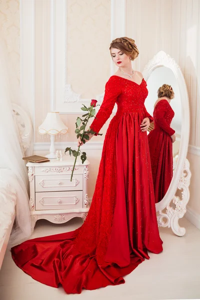 Жінка в червоному з трояндою — стокове фото