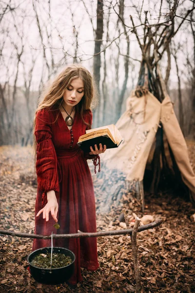 Jovem bruxa na floresta de outono — Fotografia de Stock