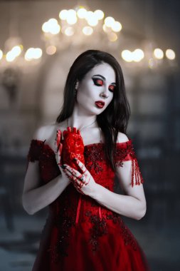 Bloodthirsty female vampire in red dress. Medieval interior clipart